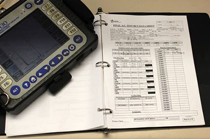 A vibration analysis meter sitting on a HECO report.