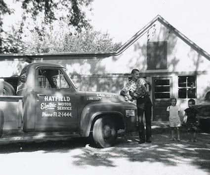 Archival image of HECO's founder and his family with an old company truck.