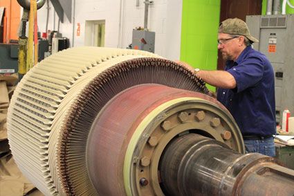 HECO technician checking in on an electric motor while it's undergoing testing.