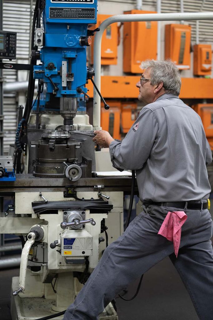 Worker operating a mill in HECO's workshop.