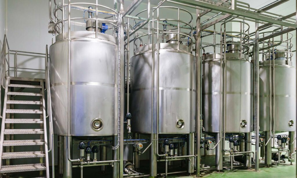 Stainless steel pharmaceutical fermentation tanks in a cleanroom environment.