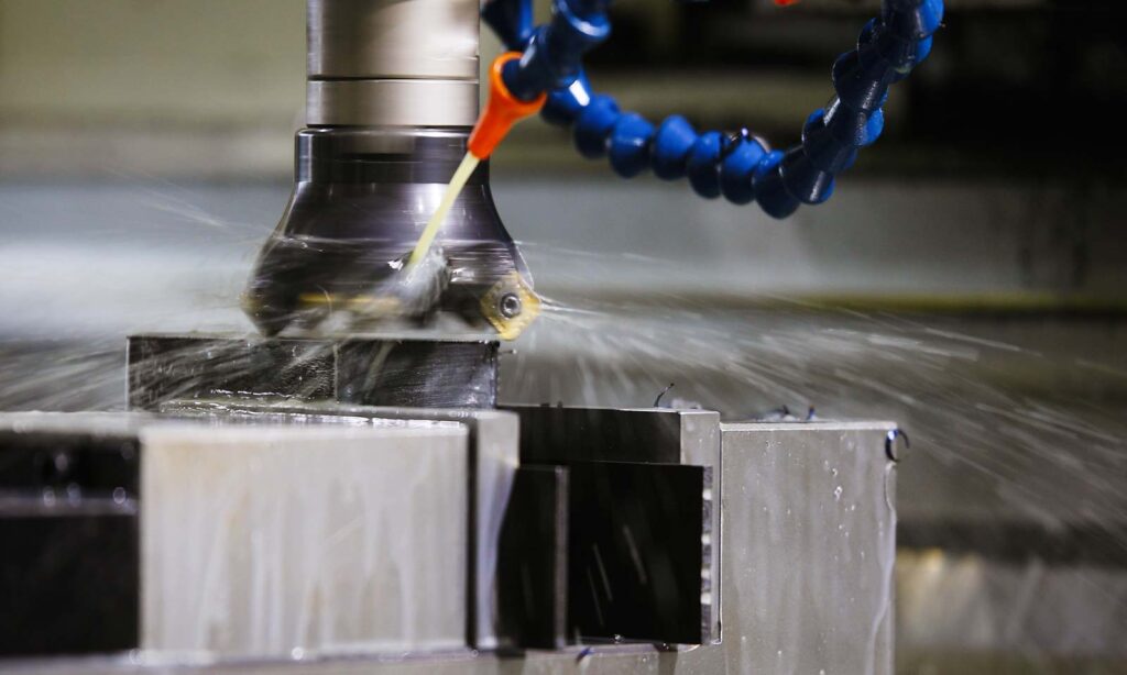 Close-up of liquid-cooled CNC metal machining to prevent overheating during high-speed cutting.