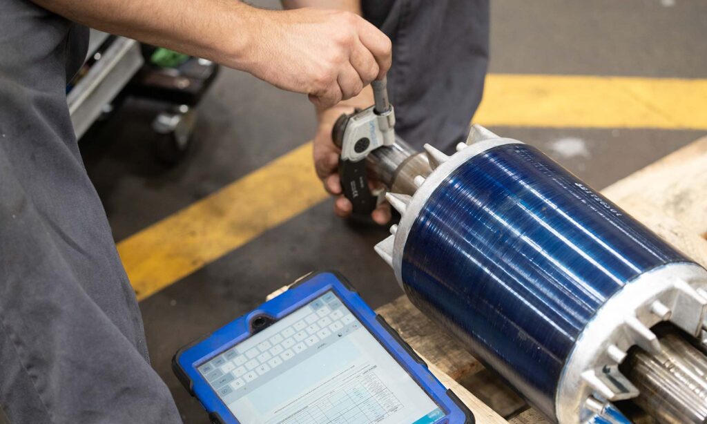 Precision measurement of motor shaft tolerance in HECO's workshop.