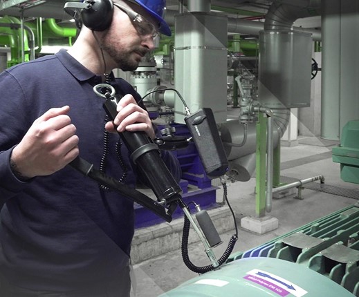 Technician using an oil checker to do oil analysis by sticking it into a motor.